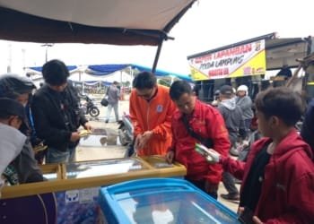 Pemudik mengambil es krim secara gratis di Pelabuhan Panjang.