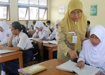 Guru sedang mengajar seorang siswanya.