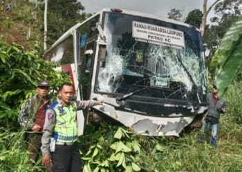 Petugas kepolisian memperlihatkan kondisi Bus Ranau Indah usai terjun ke jurang di jalur lintas Pekon Padang Tambak Kecamatan Way Tenong, Lampung Barat, Senin, 13 Mei 2024.