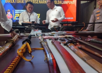 Polisi saat konferensi pers di Polda Lampung dan senjata tajam. (Foto: Lampost.co/Salda Andala)