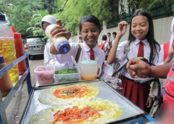 Sejumlah siswa sekolah dasar antre ketika membeli jajanan yang dijual di depan sekolah mereka. Dok/Antara