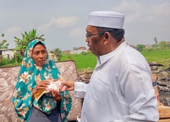 Pimpinan Ponpes Riyadhus Sholihin KH Ismail Zulkarnain menyerahkan bantuan kepada Sri Wahyuni, korban kebakaran di Desa Fajar Baru, Kecamatan Jati Agung, Lampung Selatan, Rabu, 17 Juli 2024. Dok
