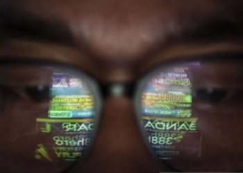 Ilustrasi - Refleksi tampilan gawai saat warga saat melihat iklan judi online di Jakarta. Dok/Antara