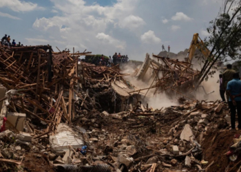 Petugas mencari sisa korban di tempat pembuangan akhir di Kampala, Uganda