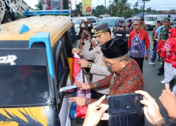 Hari Veteran Nasional. Pj Bupati Lampung Utara Aswarodi bersama Forkopimda Lampura membagikan bendera kepada masyarakat. Dok/Dinas Kominfo Lampura