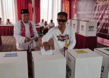 Petugas Kelompok Penyelenggara Pemungutan Suara (KPPS) mendampingi salah satu warga tuna netra saat memasukan surat suara ke kotak suara dalam simulasi pemungutan dan penghitungan suara Pemilu 2024 di Kantor KPU Jakarta Timur, Pulogadung, Senin (18/12/2023). ANTARA/Syaiful Hakim.