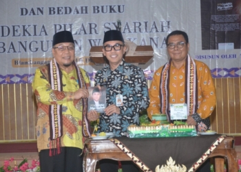 Wakil Ketua 1 Bidang Organisasi dan Kelembagaan ICMI Wilayah Lampung, Tony Eka Candra, menerima buku dari Ketua ICMI Way Kanan yang juga Bupati Way Kanan, Raden Adipati Surya, saat meluncurkan buku bertajuk 'Cendekia Pilar Syariah Pembangunan Way Kanan', Rabu (10/12/2024). Lampost.co/Hendrivan Gumala