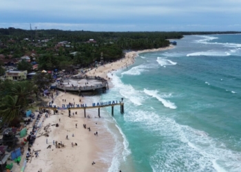 Wisatawan menikmati indahnya pantai Labuhan jukung, Rabu, 1 Januari 2025. (Foto: Salda Andala/Lampost.co)
