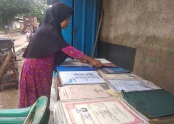 Santi warga Way Lunik, Panjang terdampak banjir Bandar Lampung menjemur dokumen berharga dan ijazah, Sabtu, 18 Januari 2025. Lampost.co/Andi Apriadi