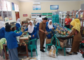 Guru dan siswa di SMAN 8 Bandar Lampung saat menyiapkan bantuan untuk siswa terdampak banjir. Lampost.co/Umar Robbani