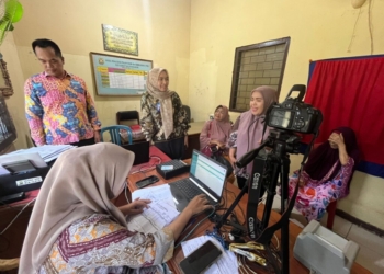 Warga terdampak banjir saat mengurus dokumen kependudukan melalui Dinas Kependudukan dan Catatan Sipil Kota Bandar Lampung, Jumat, 24 Januari 2025. Lampost.co/Andi Apriadi