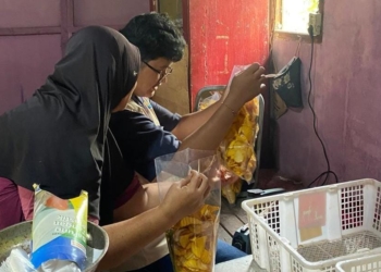 Mahasiswa KKN membantu pelaku UMKM membungkus keripik. Dok/Istimewa