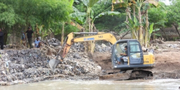 Seorang pekerja sedang mengoperasikan alat excavator untuk mengeruk sedimentasi dalam rangka normalisiasi sungai. Dok/Dinas PU Bandar Lampung