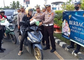 Aparat Polres Lampung Utara membagikan hidangan buka puasa kepada pengguna jalan di bilangan Jalinsumteng, Bundaran Payan Mas Kotabumi, Kamis, 6 Maret 2025. Lampost.co/Fajar Nofitra