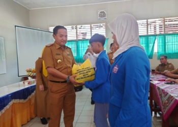 Kadisdikbud Lampung menyerahkan bantuan terhadap korban banjir. (Lampost/Umar Robbani)