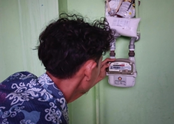 Salah satu pelanggan gas PGN mengecek meteran gas. (Lampost/Umar)