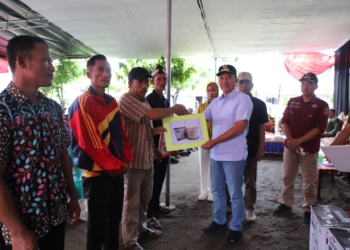 Bupati Lampung Barat Parosil Mabsus saat menyerahkan bantuan sarana pertanian, Senin 12 Mei 2025. Lampost.co/Eliyah