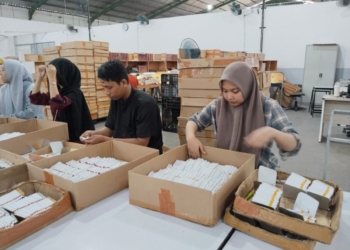 Pekerja pabrik sedang melakukan packing rokok. (Lampost.co // Atika)