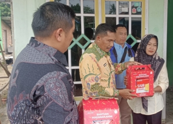 Kepala Dinsos Lampung Utara, Imam Hanafi saat memberikan bantuan kepada warga. Dok Dinsos