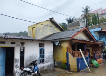 Hujan lebat disertai angin kencang di Kampung Sukajadi Pidada, Kecamatan Panjang, Bandar Lampung, Selasa siang, 7 Oktober 2025 mengakibatkan atap rumah milik Pak Ujang terbang terbawa angin dan menghantam rumah tetangganya. (Foto: Lampost.co / Magang Bodi Man)