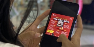 Seorang anak muda tengah membaca informasi jebakan pinjol. Dok Antara