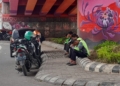 Mitra ojek online sedang beristirahat sambil menunggu orderan di bawah flyover Mall Boemi Kedaton, Jalan Sultan Agung, Bandar Lampung, Kamis, 27 November 2025. (Foto: Lampung Post/Triyadi Isworo)