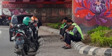 Mitra ojek online sedang beristirahat sambil menunggu orderan di bawah flyover Mall Boemi Kedaton, Jalan Sultan Agung, Bandar Lampung, Kamis, 27 November 2025. (Foto: Lampung Post/Triyadi Isworo)