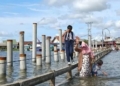 Warga Pesisir Bandar Lampung sedang melewati banjir rob atau pasang air laut maksimum. Dok Lampost.co