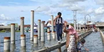 Warga Pesisir Bandar Lampung sedang melewati banjir rob atau pasang air laut maksimum. Dok Lampost.co