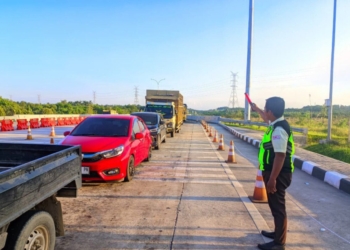Petugas sedang memberikan arahan kepada kendaraan yang melintasi Jalan Tol Trans Sumatera (JTTS). Dok Hutama Karya
