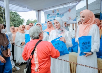 Ketua TP PKK Provinsi Lampung Ibu Purnama Wulansari Mirza didampingi Ketua DWP Provinsi Lampung Agnesia Bulan Rurianti serta perwakilan anggota Dharma Wanita membagikan takjil kepada masyarakat di depan Rumah Dinas Gubernur Lampung, Mahan Agung, Selasa Sore (24/02/2026). Dok Adpim Lampung