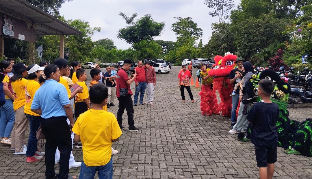 Pengunjung berfoto bersama barongsai usai pertunjukan di Lembah Hijau, Selasa, 17 Februari 2026. Lampost.co