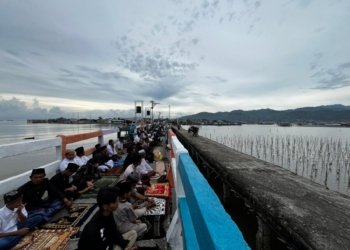 Kampung Pulau Pasaran, Cungkeng, dan wilayah sekitarnya di Kelurahan Kota Karang, Telukbetung Timur, melaksanakan ibadah salat Id berjamaah di atas jembatan warna warni, akses penghubung Pulau Pasaran, Sabtu 21 Maret 2026.
